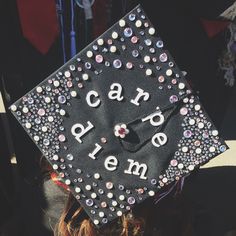 a black graduation cap with the words care and embellishments on it