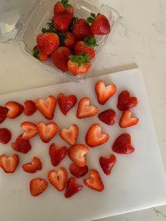 strawberries are cut up and placed on a cutting board