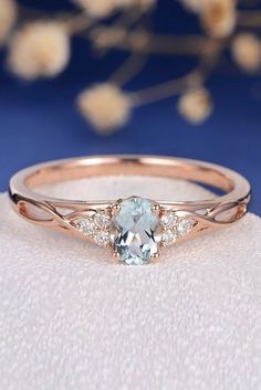 a ring with an aqua blue stone and two white diamonds on the band, sitting on a