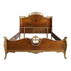 an antique style bed with gold trimmings and headboard, made from wood