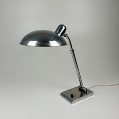 a lamp that is on top of a white surface with a cord attached to it