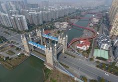 an aerial view of a bridge in the middle of a city with lots of tall buildings