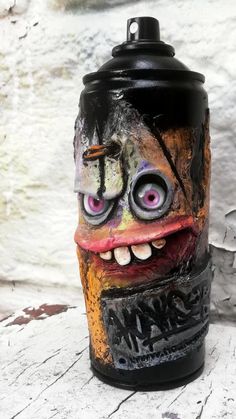 a trash can with an evil face painted on it