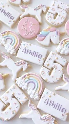 decorated cookies with unicorns, rainbows and stars are on a white tablecloth