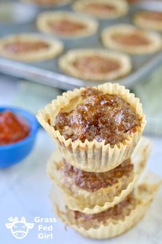 three cupcakes stacked up on top of each other with sauce in the background