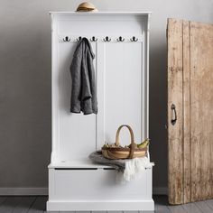 a white wooden bench sitting next to a coat rack