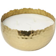 a gold metal bowl with a white candle inside