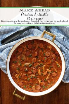 a bowl of chicken and sausage gumbo on a wooden table with a blue towel