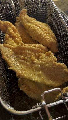 some fried food in a metal basket on a table