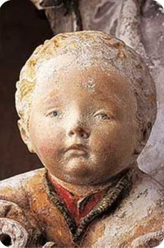 an old statue of a boy with his head turned to the side