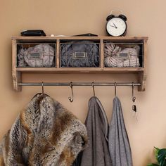 a coat rack with several coats hanging from it's sides and a clock on the wall