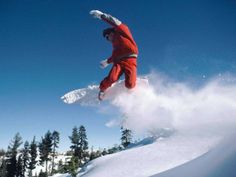 a snowboarder in red is doing a trick