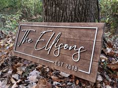 a wooden sign that says the ellfsons on it in front of a tree