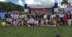 a group of people posing for a photo in front of a soccer goal at an event