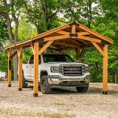 a white truck parked under a wooden carport in the middle of a park area