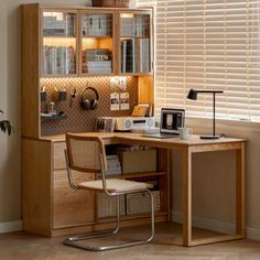 a home office with a desk, chair and bookshelf in front of the window