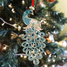 an ornament hanging from a christmas tree decorated with blue and gold jewels,