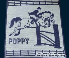 a white and blue rug with a horse and rider on it's back in front of a fence