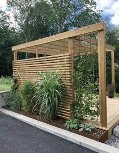 a wooden gazebo surrounded by plants and trees