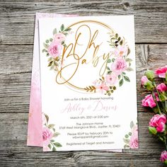 a pink and gold baby shower with flowers on the side, next to it is a card