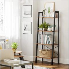 a living room filled with furniture and a tall book shelf next to a window on top of a hard wood floor