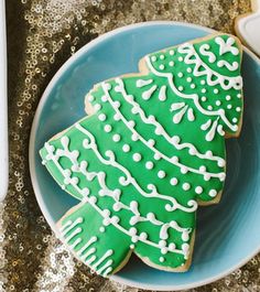 two decorated christmas tree cookies on a blue plate