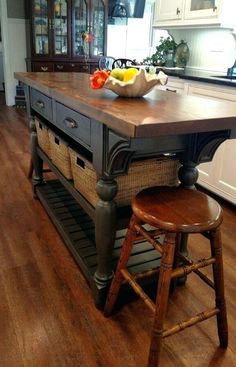 a kitchen island with two stools in front of it and a basket on top