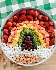 a bowl filled with fruit and marshmallows on top of a table