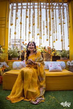 a woman sitting on top of a yellow couch