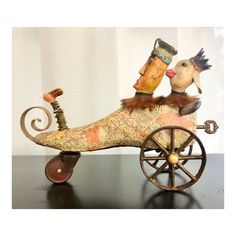 an old fashioned wooden toy with two birds riding on it