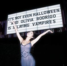 a woman holding up a sign that says it's not even halloween and olvia rodigoo is staying vampires