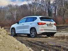 a white car parked on top of a dirt field