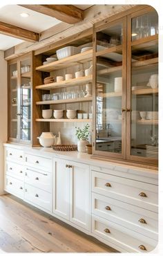 a kitchen with white cabinets and glass doors on the front, and wooden shelves in the back