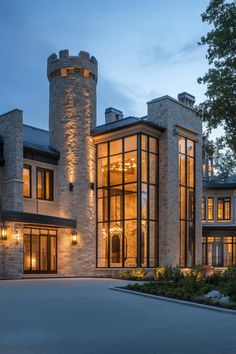 a large stone building with lots of windows and lights on it's front entrance