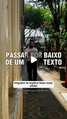 a man walking down a sidewalk next to a tall white building with the words passar por baxo de um explicar fazer se effiio