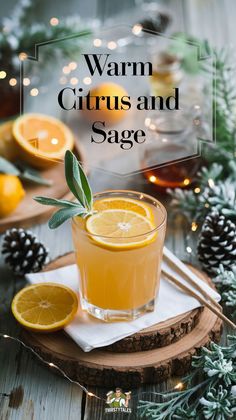 warm citrus and sage drink in a glass on a wooden tray surrounded by pine cones