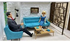 a man and woman sitting on couches in a living room, talking to each other