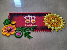 this is an image of a decorated mat on the floor with flowers and beads around it