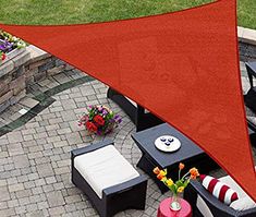 an outdoor patio with furniture and a red triangle shade