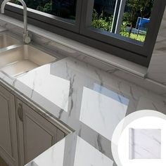 a kitchen with marble counter tops and stainless steel sink faucet in front of a window