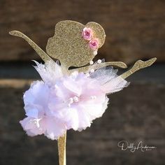 a pink and gold cake topper with a flower on it