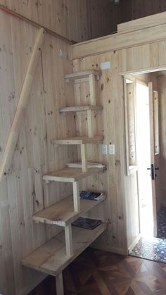 a room with wooden walls and shelves on the wall, along with wood flooring