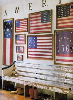 a wooden bench sitting in front of a wall with american flags on it