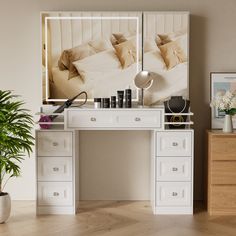 a white desk topped with drawers and a mirror next to a potted plant on top of a hard wood floor