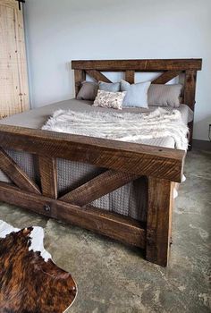 a bed made out of wooden planks in a room with a cow rug on the floor