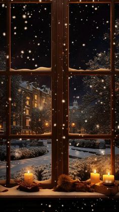 an open window with candles lit in front of it and snow falling on the ground