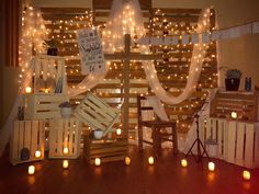 a room with lights and wooden crates on the floor in front of a wall that has candles around it