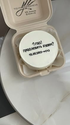 a cake in a box with writing on it sitting on top of a white table