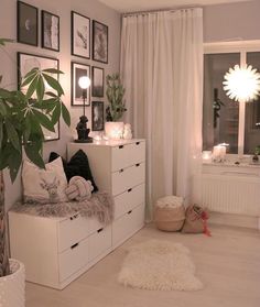 a living room with white furniture and pictures on the wall above it's windows