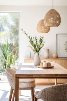 a dining room table with chairs and vases on it